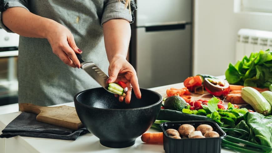 Zucchini-Paprika-Pfanne Frau bereitet Gemüse in der Küche zu