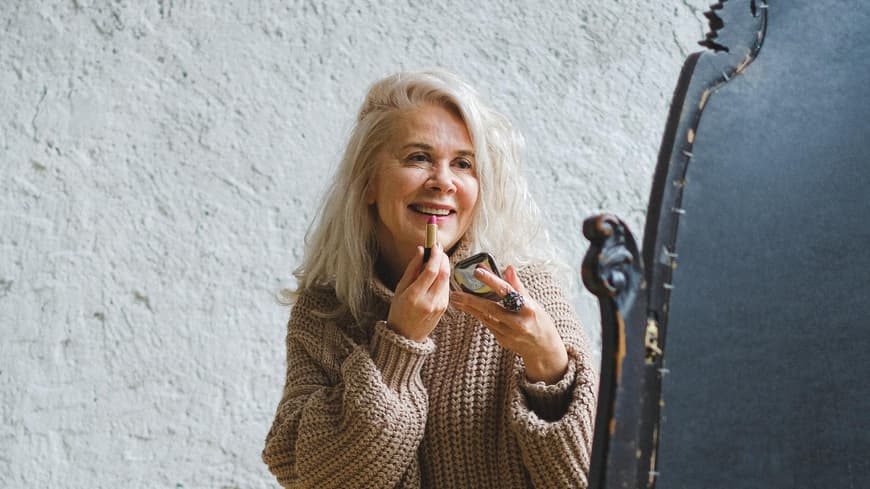 Lippenstiftfarbe Frauen ab 50 Frau trägt Lippenstift auf