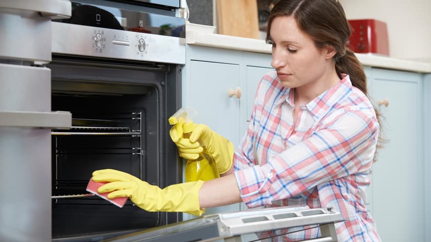 Frau putzt Backofen