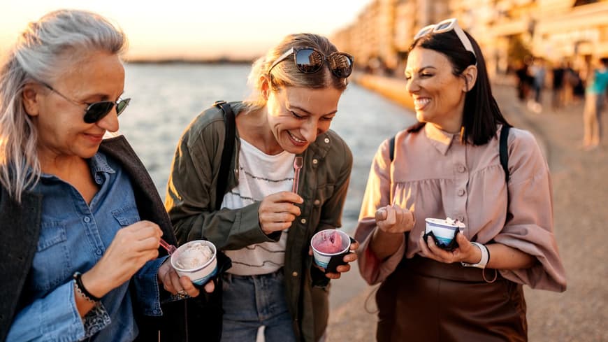Mädelswochenende Ideen Drei Frauen lachen essen ein Eis im Becher