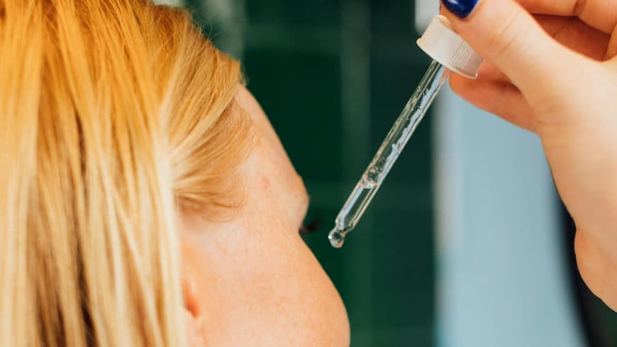 Frau trägt Serum auf ihr Gesicht auf Frau trägt Serum auf ihr Gesicht auf