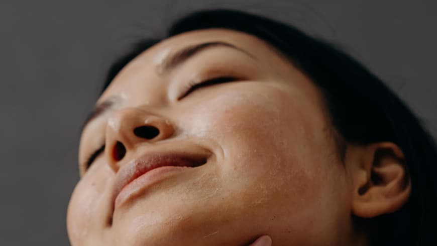 Sonnencreme fuer Allergiker Frau traegt Sonnencreme auf