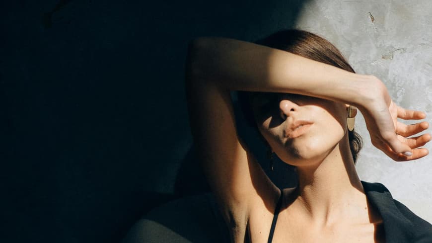 Woran man unsichere Menschen erkennt und wie man helfen kann. Frau verdeckt ihr Gesicht