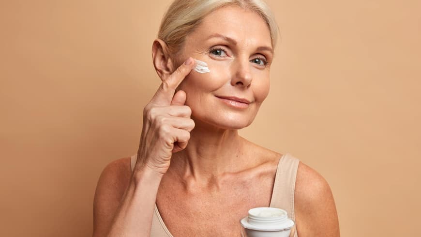 Der neue, innovative Anti-Aging-Wirkstoff Eisenkraut Frau trägt Creme aufs Gesicht