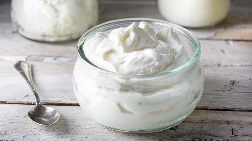 Jeden Tag Quark essen, kann sich auf den Körper auswirken. Glasschale mit Quark