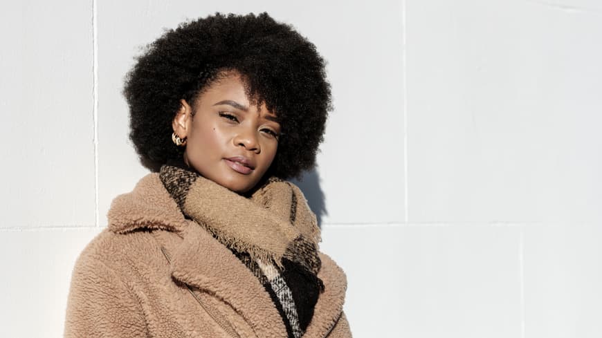 Welche Sternzeichen besonders rücksichtslos sind, erfährst du hier. Frau vor weißer Wand