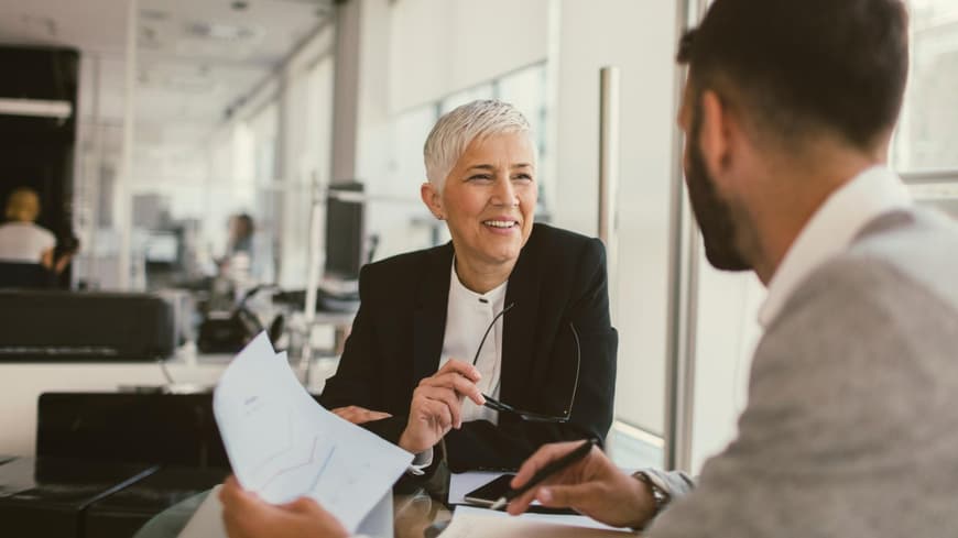 Manche Vornamen kommen in Führungspositionen öfter vor. Frau sitzt mit einem Mann im Büro am Schreibtisch