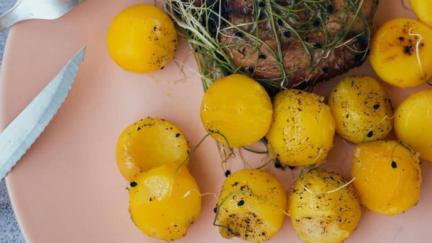 Kartoffeldiät ist eine spezielle Diätform. Kartoffeln und Fleisch auf einem rosanen Teller.