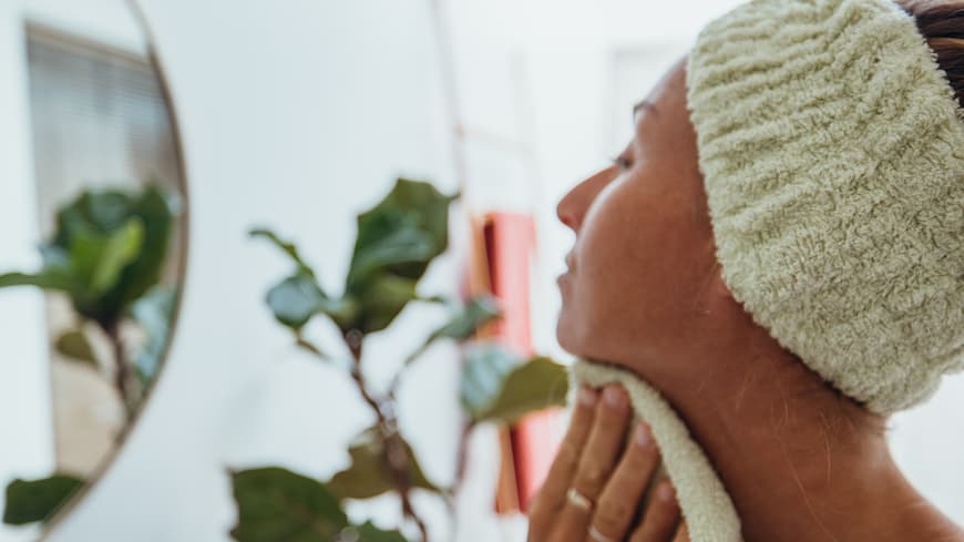 Wie oft du dein Handtuch fürs Gesicht wechseln solltest, erklärt eine Dermatologin. Frau trocknet ihr Gesicht ab