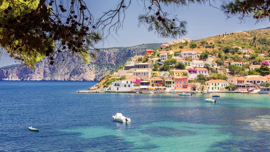 Kefalonia überzeugt mit seinem besonderen Charme. Die Küste von Kefalonia mit bunten Häusern und Booten auf dem Wasser.