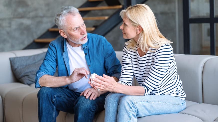 Männer wünschen sich in einer Beziehung Würdigung. Mann und Frau sitzen auf einer hellen Coach und führen ein Gespräch.