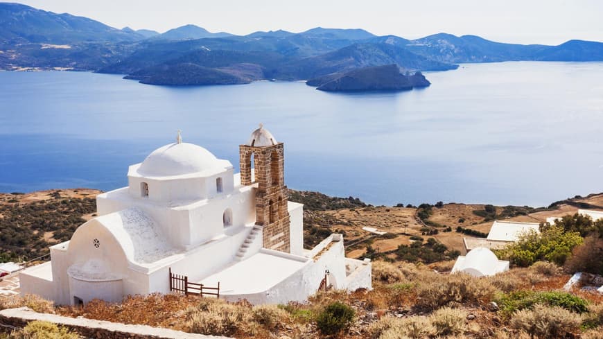 Die Insel Milos gilt als Geheimtipp in Griechenland. Eine griechische Kapelle mit dem Meer und Landschaft im Hintergrund.