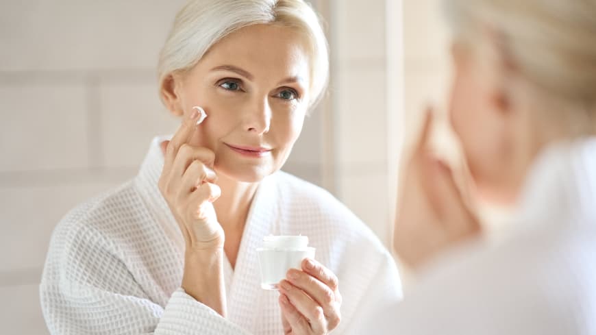 Probiotische Hautpflege liegt total im Trend – und das aus guten Gründen. Frau cremt ihr Gesicht ein