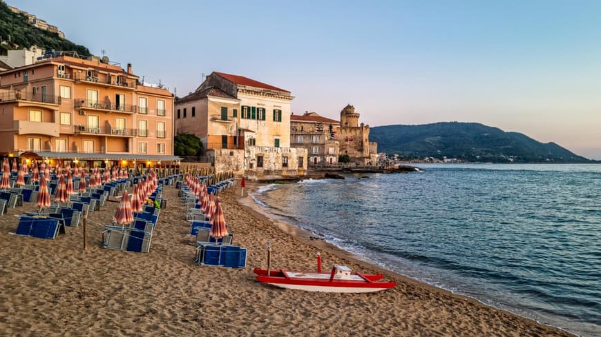 Cilento bietet einen ruhigen Strand zum Erholen. Strand von Cilento mit Häusern, Liegen und Sonnenschirmen.