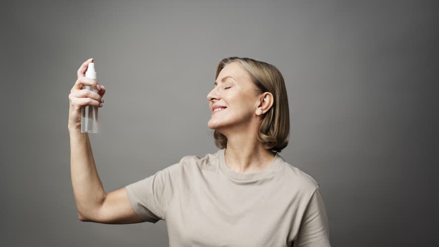 Hypochlorous Acid Sprays sind der Skincare-Trend 2025 – aus gutem Grund. Frau sprüht Gesichtsspray in ihr Gesicht.
