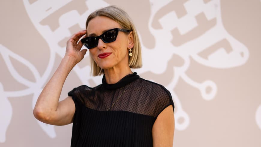 Kurzhaarfrisuren ab 40 sind praktisch und stylish zugleich. Frau mit kurzen, blonden Haaren, roten Lippen und einer schwarzen Sonnenbrille.