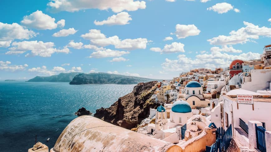 Santorini hat viele süße Häuser zu bieten. Bunte Häuser von oben an der Küste zum Meer