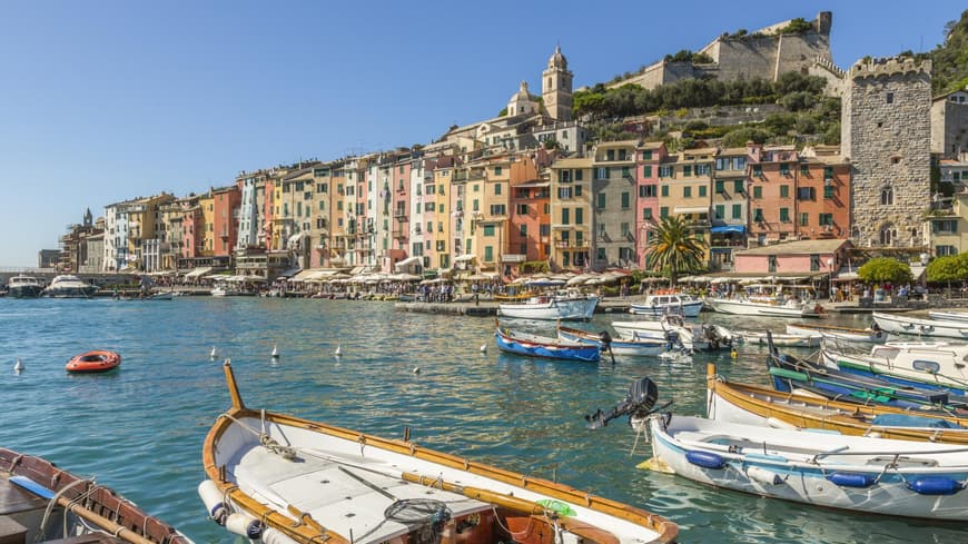 In Portovenere kannst du viele bunte Häuser finden. Ein Blick auf bunte Häuser und den Hafen von Portovenere mit kleinen Fischerbooten.