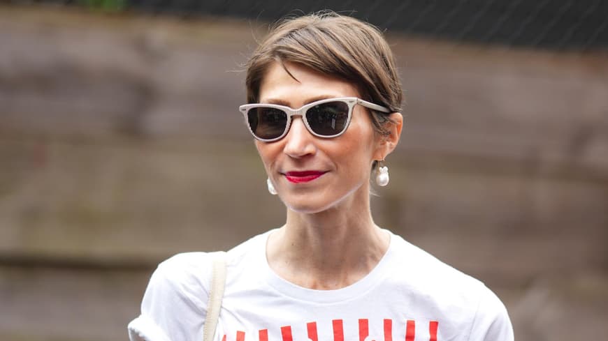 Lip Stain zaubert den ganzen Tag frische Lippenfarbe. Frau mit braunhaarigem Kurzhaarschnitt, einer beigen Sonnenbrille und roten Lippen.