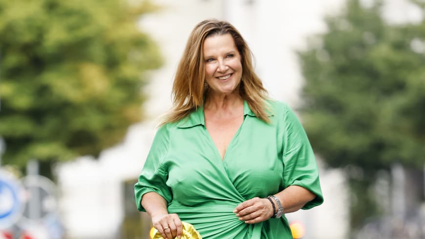 Wir haben die besten Stylingtipps für Frauen ab 50 mit Bauch. Frau in grünem Wickelkleid