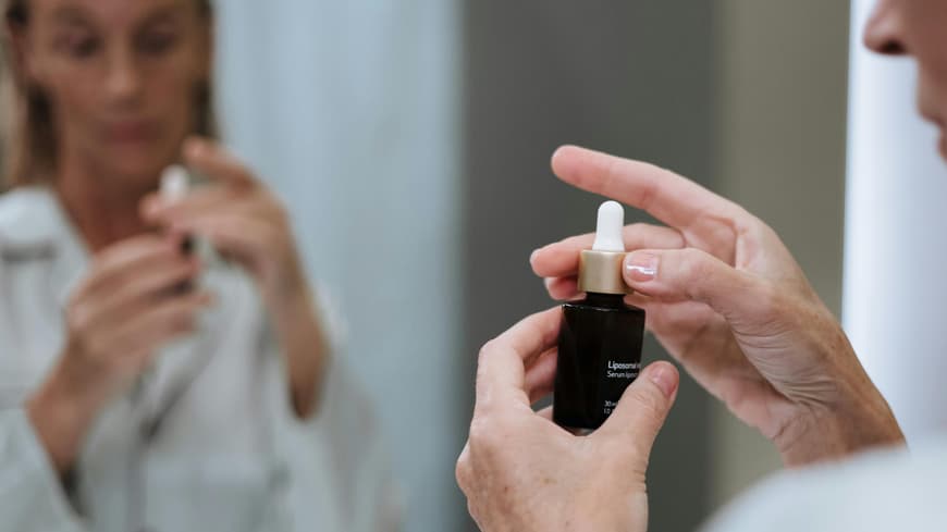Sulfur-Skincare ist der effektive Hautpflege-Trend gegen Unreinheiten. Frau hält Hautpflegeserum in der Hand.
