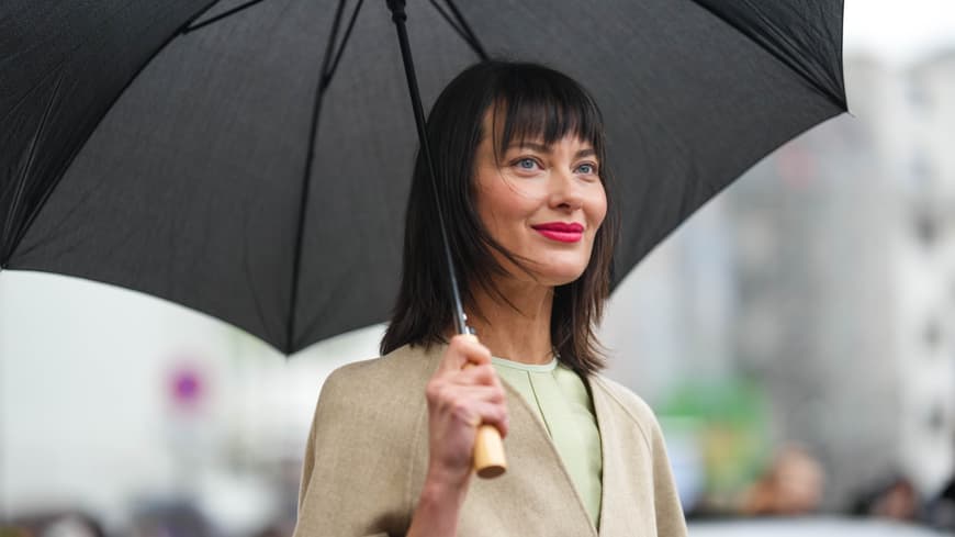 Wie bleibt unsere Frisur trotz Wind und Wetter frisch? Das verraten uns jetzt Haar-Stylisten! Frau mit Regenschirm