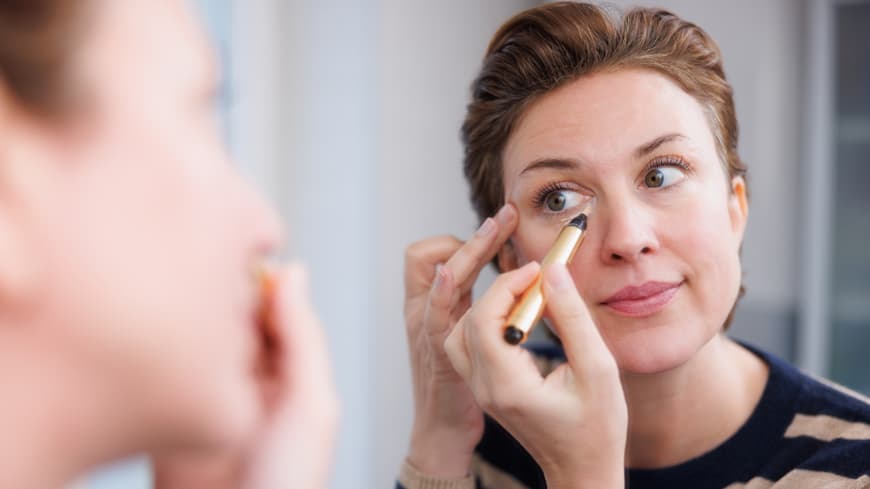 Frau trägt Concealer auf Frau trägt Concealer auf