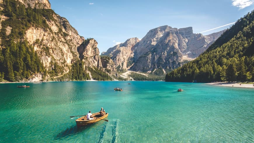 In der Natur lässt sich am besten der Kopf ausschalten. Ein großer See mit Gebirge im Hintergrund und ein paar Booten auf dem Wasser.