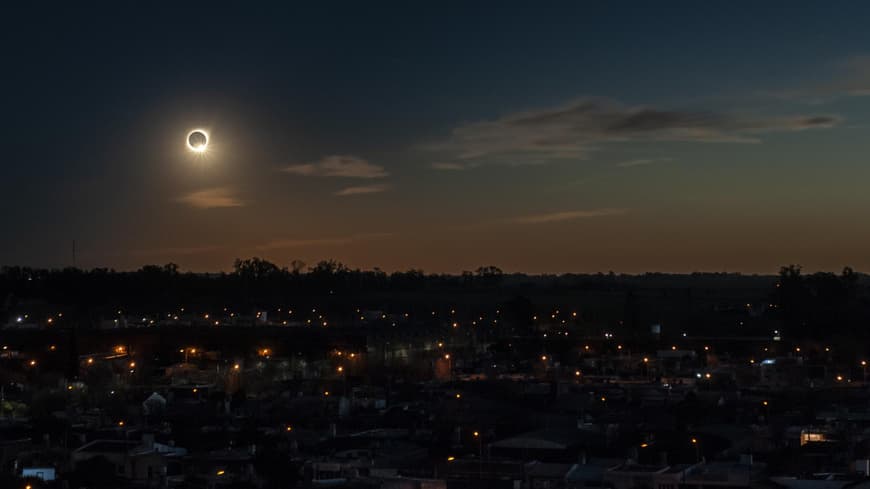 In diesem Jahr erleben wir eine totale Sonnenfinsternis im August. Totale Sonnenfinsternis über den Dächern einer Stadt.