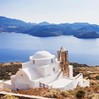 Die Insel Milos gilt als Geheimtipp in Griechenland. Eine griechische Kapelle mit dem Meer und Landschaft im Hintergrund.