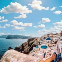 Santorini hat viele süße Häuser zu bieten. Bunte Häuser von oben an der Küste zum Meer