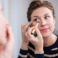 Frau trägt Concealer auf Frau trägt Concealer auf