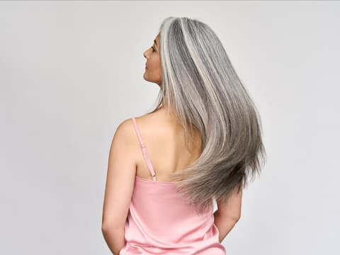 Anti-Aging für die Haare Frau mit langen, grauen Haaren.