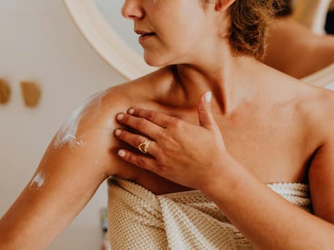 Die besten Bodylotions für Frauen ab 50 Frau cremt sich ein
