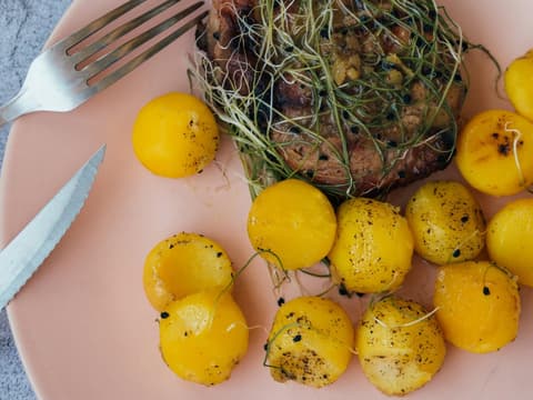 Kartoffeldiät ist eine spezielle Diätform. Kartoffeln und Fleisch auf einem rosanen Teller.