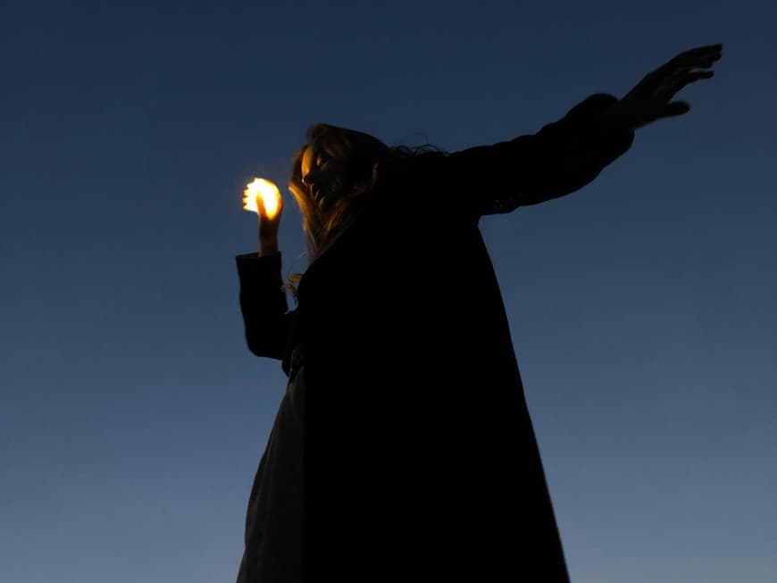 Sternzeichen, die Pech im Oktober haben Frau hält eine kleine Lichtkugel in der Hand