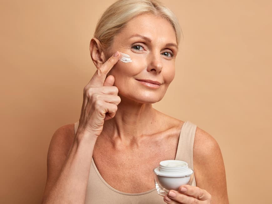 Der neue, innovative Anti-Aging-Wirkstoff Eisenkraut Frau trägt Creme aufs Gesicht