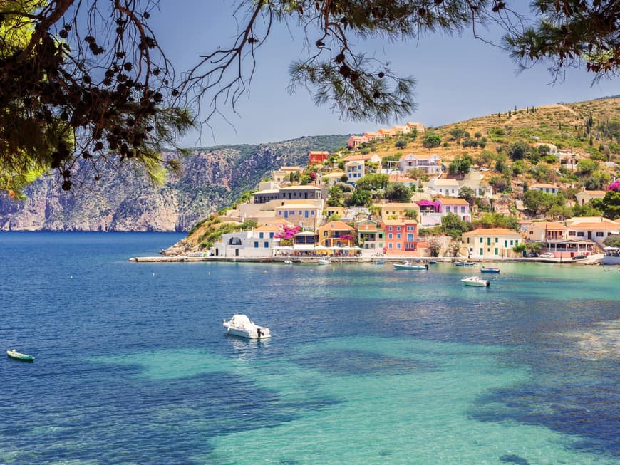 Kefalonia überzeugt mit seinem besonderen Charme. Die Küste von Kefalonia mit bunten Häusern und Booten auf dem Wasser.