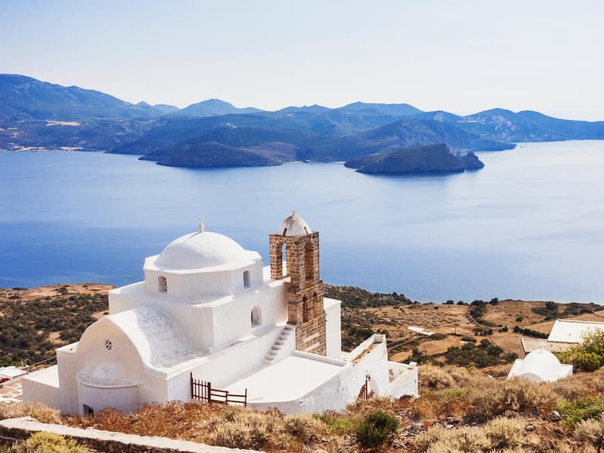 Die Insel Milos gilt als Geheimtipp in Griechenland. Eine griechische Kapelle mit dem Meer und Landschaft im Hintergrund.