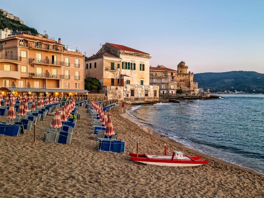 Cilento bietet einen ruhigen Strand zum Erholen. Strand von Cilento mit Häusern, Liegen und Sonnenschirmen.