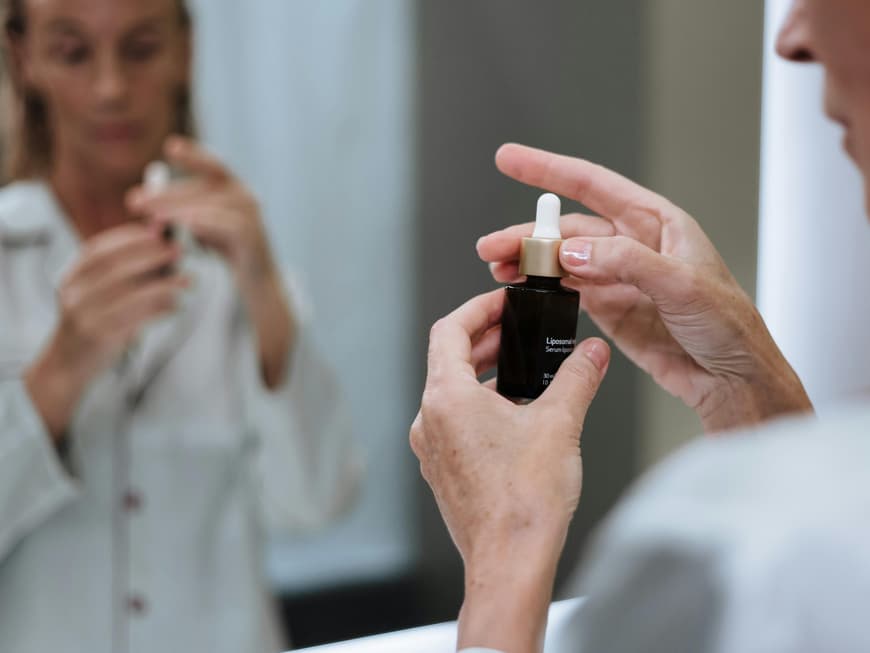 Sulfur-Skincare ist der effektive Hautpflege-Trend gegen Unreinheiten. Frau hält Hautpflegeserum in der Hand.
