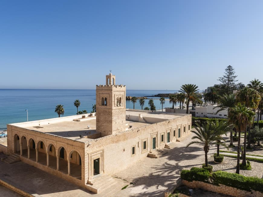 Die Moschee von Monastir lockt viele Menschen nach Tunesien. Große Moschee von Monastir in Tunesien mit Palmen drum herum.